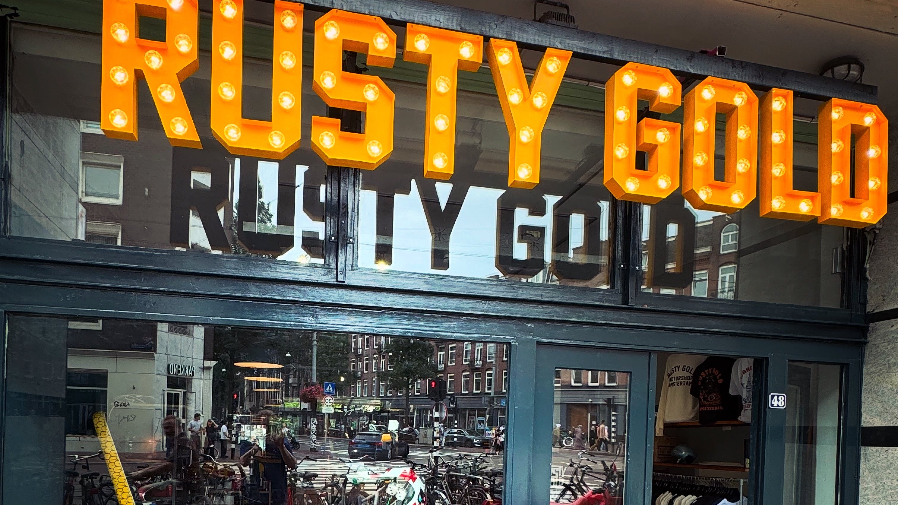 Storefront with 'Rusty Gold' sign and motorcycle display